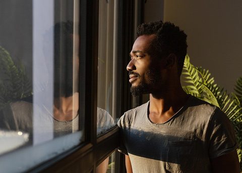 Homme noir qui regarde par la fenêtre